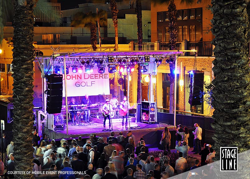 Stageline SL100 mobile stage lit up for an evening outdoor concert